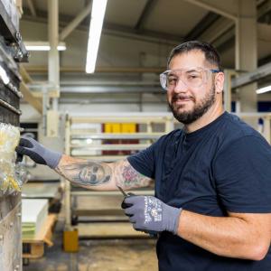 Young man working on machine and smiling into the camera