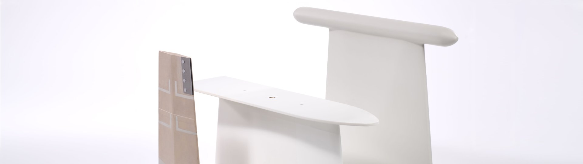 Several light-colored, smoothly shaped components with rounded edges are arranged side by side and vary in size.